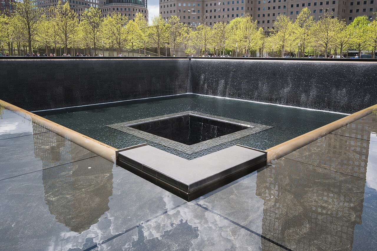 Canto da piscina norte do Memorial Nacional do 11 de Setembro, em Nova York, com a água descendo pelas paredes de granito