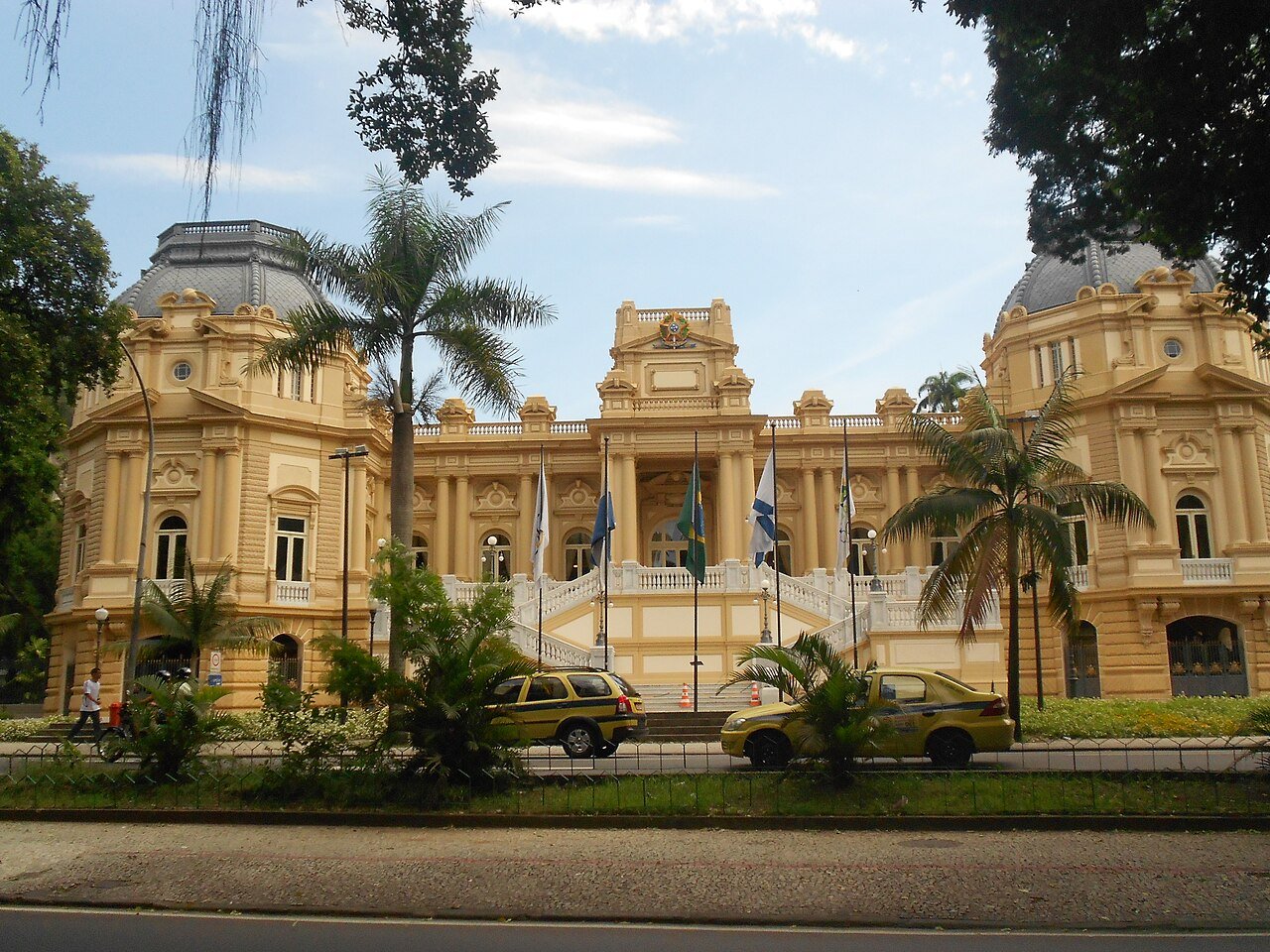 Fachada do Palacio Guanabara, sede do governo do Rio de Janeiro, com bandeiras hasteadas e palmeiras em frente