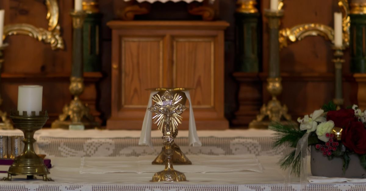 Altar de igreja católica com custódia, velas e flores (imagem ilustrativa)
