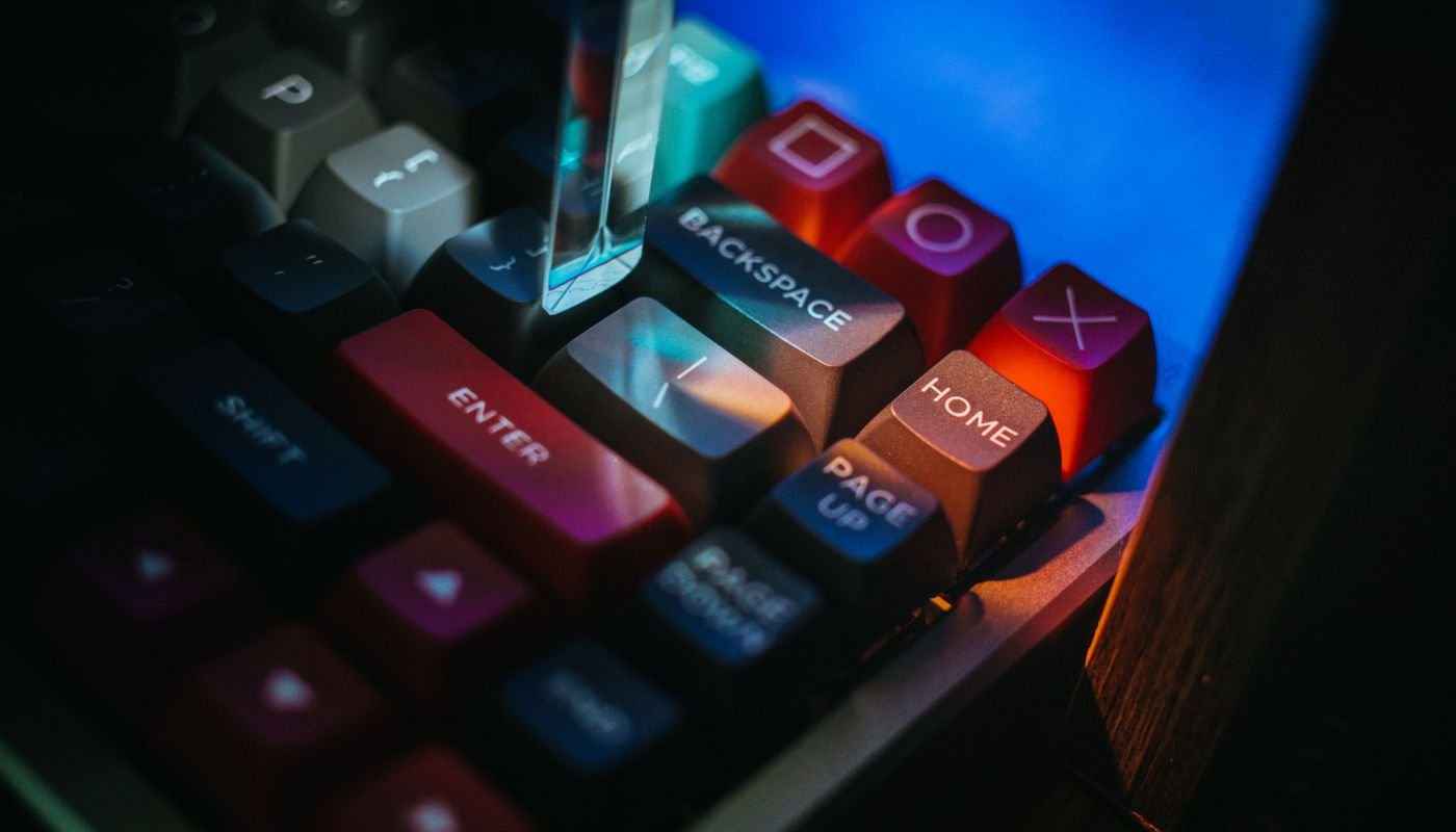Teclado mecânico de computador com iluminação colorida em ambiente escuro