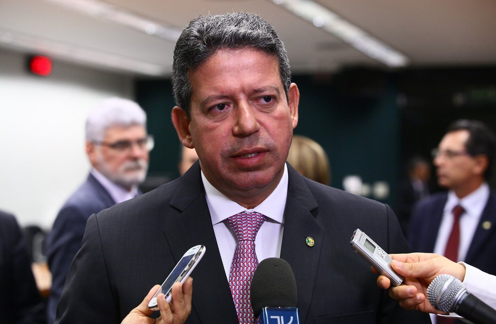 Arthur Lira fala a jornalistas cercado por microfones e gravadores