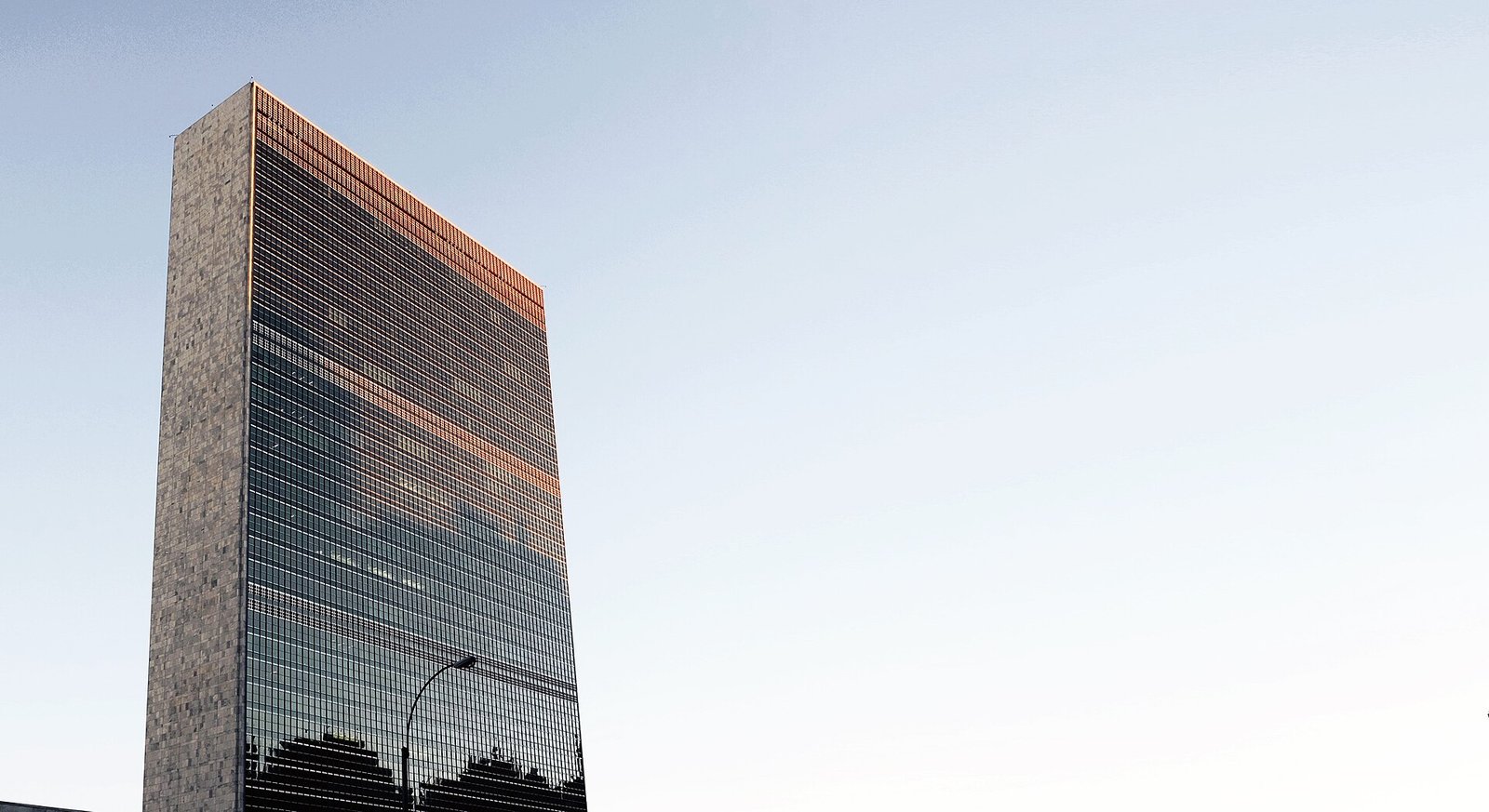 Edifício-sede da Organização das Nações Unidas, em Nova York, visto de baixo ao entardecer