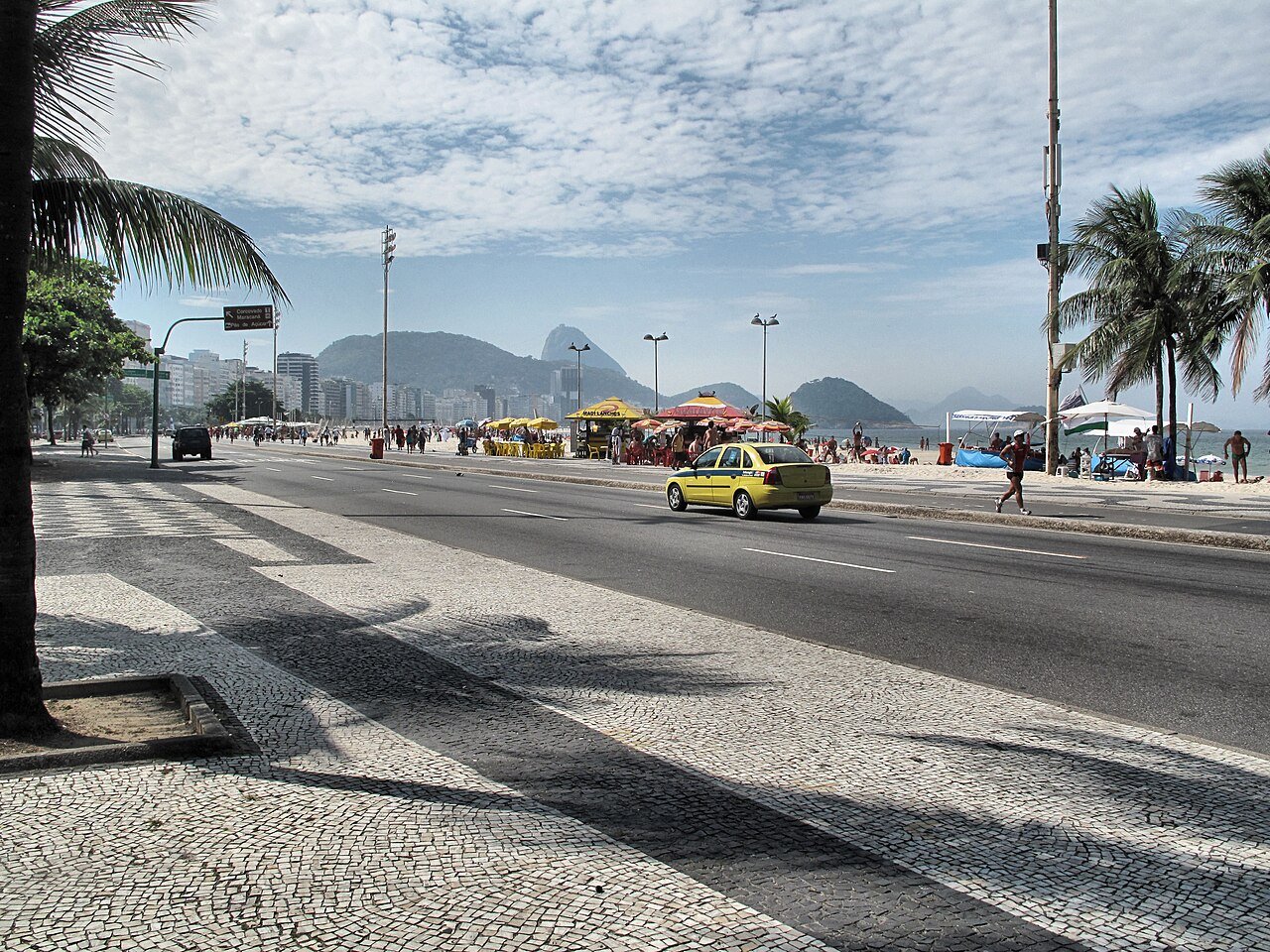 Avenida Atlantica em Copacabana, no Rio de Janeiro, com calcadao, praia e Pao de Acucar ao fundo