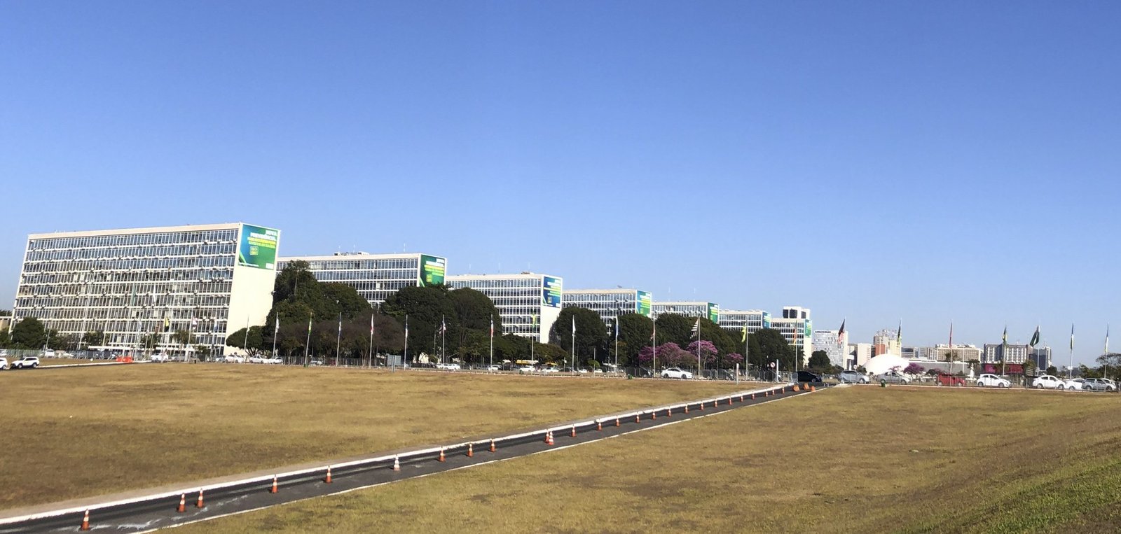 Fileira de prédios da Esplanada dos Ministérios, em Brasília, vista do gramado do Eixo Monumental