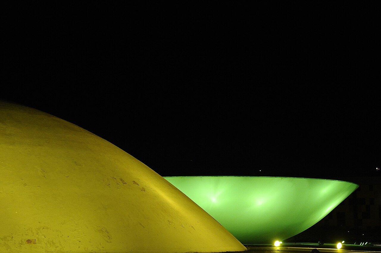 Cúpula do Senado e cúpula voltada para cima da Câmara dos Deputados iluminadas à noite, em Brasília, foto de arquivo