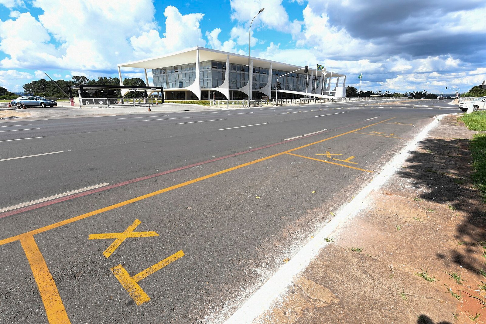 Fachada do Palácio do Planalto vista da via, com a bandeira do Brasil hasteada