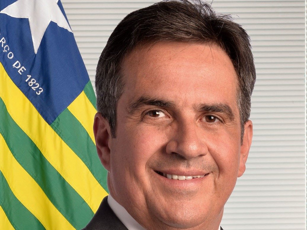 Retrato oficial do senador Ciro Nogueira diante da bandeira do Piauí