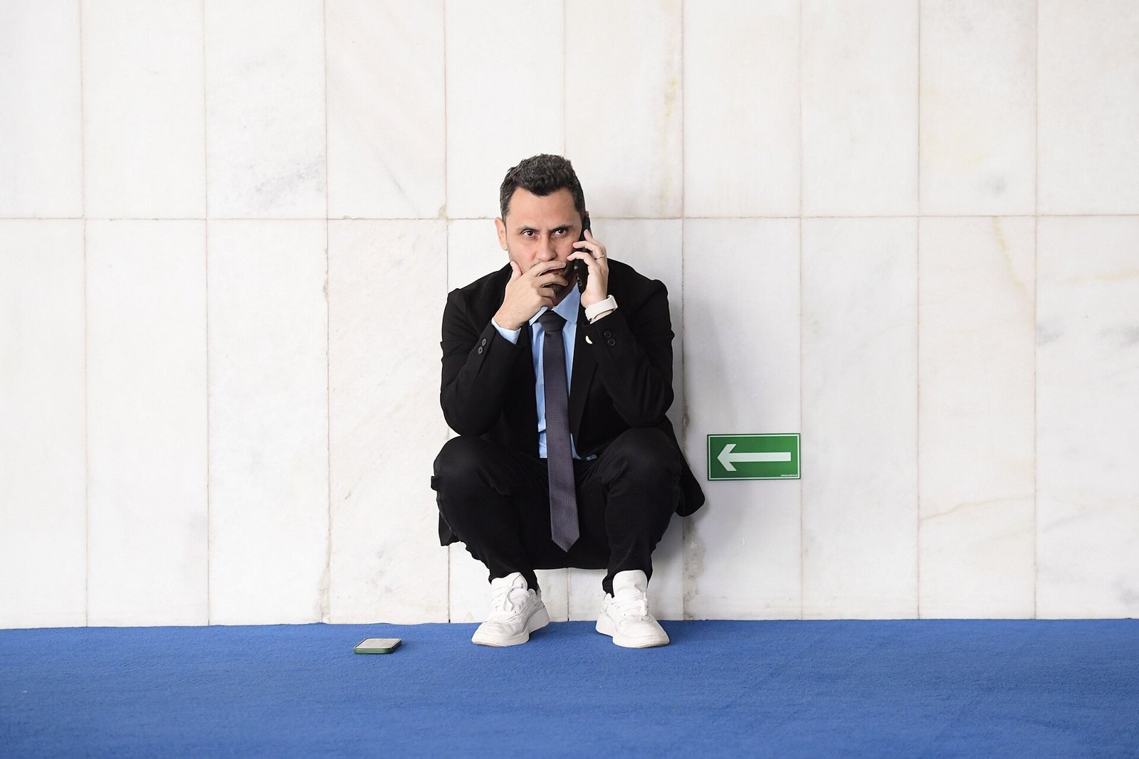 Senador Cleitinho ao telefone em corredor do Senado Federal