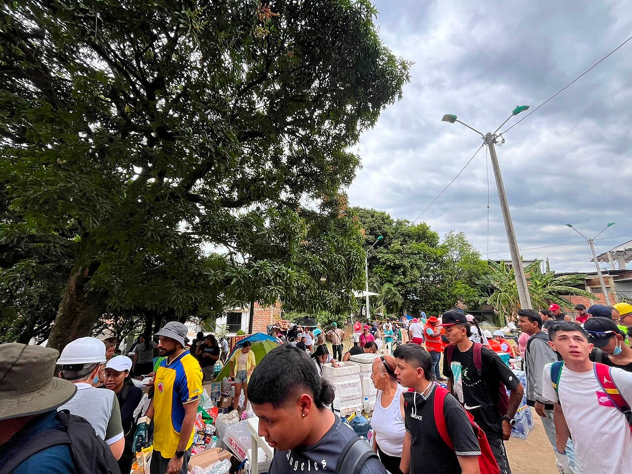 Moradores desabrigados reunidos em ponto de distribuicao de mantimentos ao ar livre em Cali, na Colombia