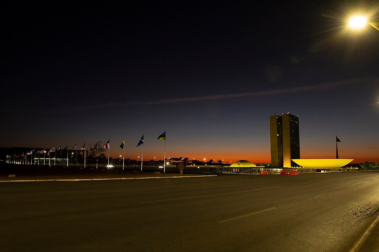 Congresso Nacional ao entardecer, com as bandeiras dos estados na Esplanada