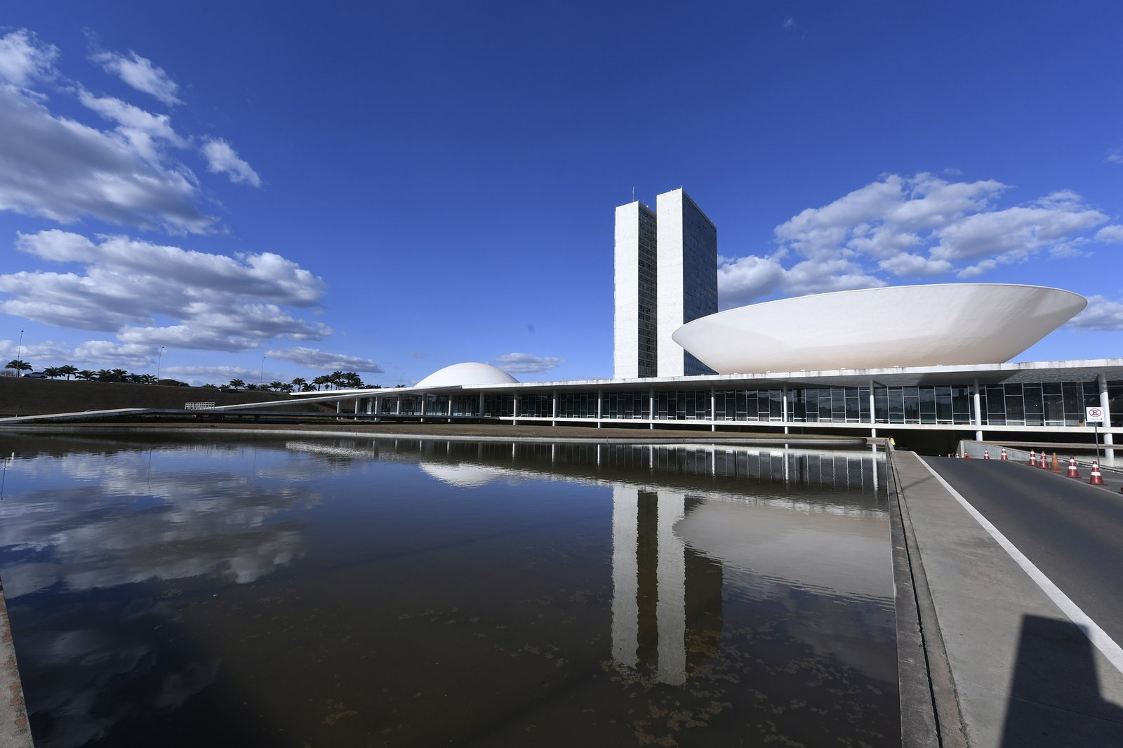 Fachada do Congresso Nacional em Brasília, com as cúpulas e as torres refletidas no espelho d'água