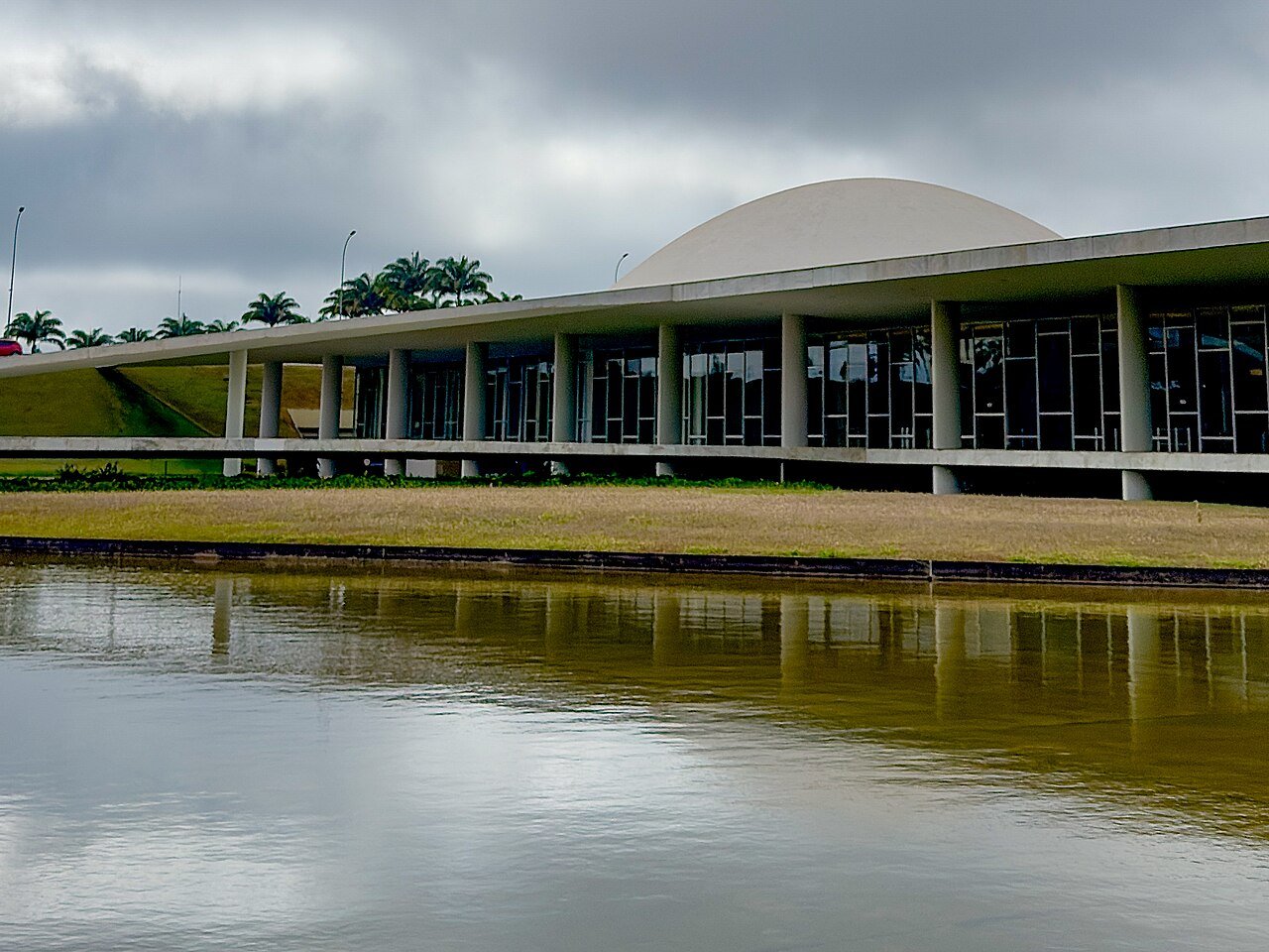 Fachada do Congresso Nacional, em Brasília, vista do espelho d'água em dia nublado