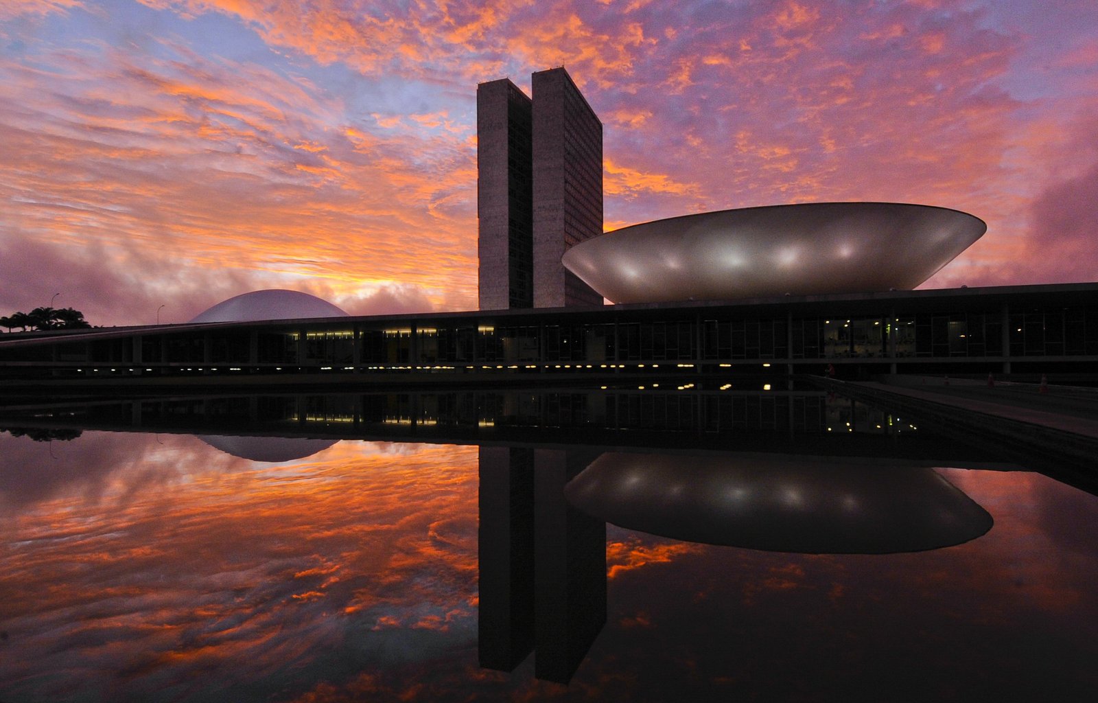 Congresso Nacional ao amanhecer, com o espelho d'agua refletindo as cupulas e as torres gemeas
