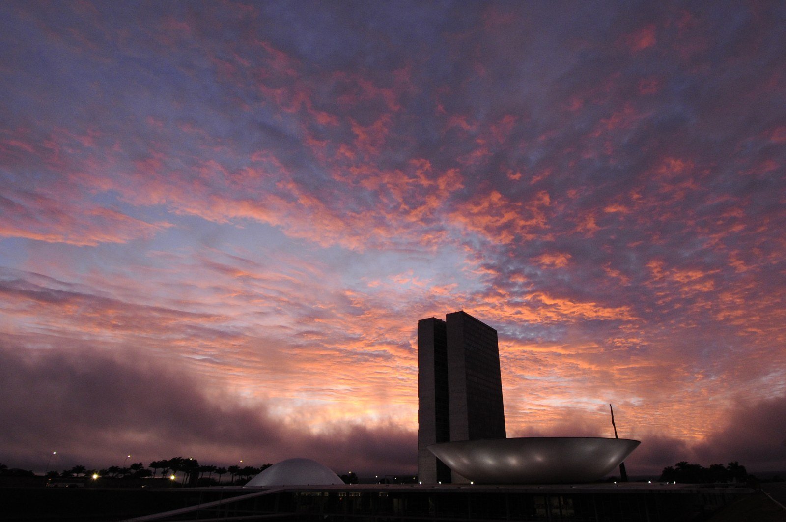 Fachada do Palácio do Congresso Nacional ao amanhecer, com as cúpulas do Senado e da Câmara em silhueta