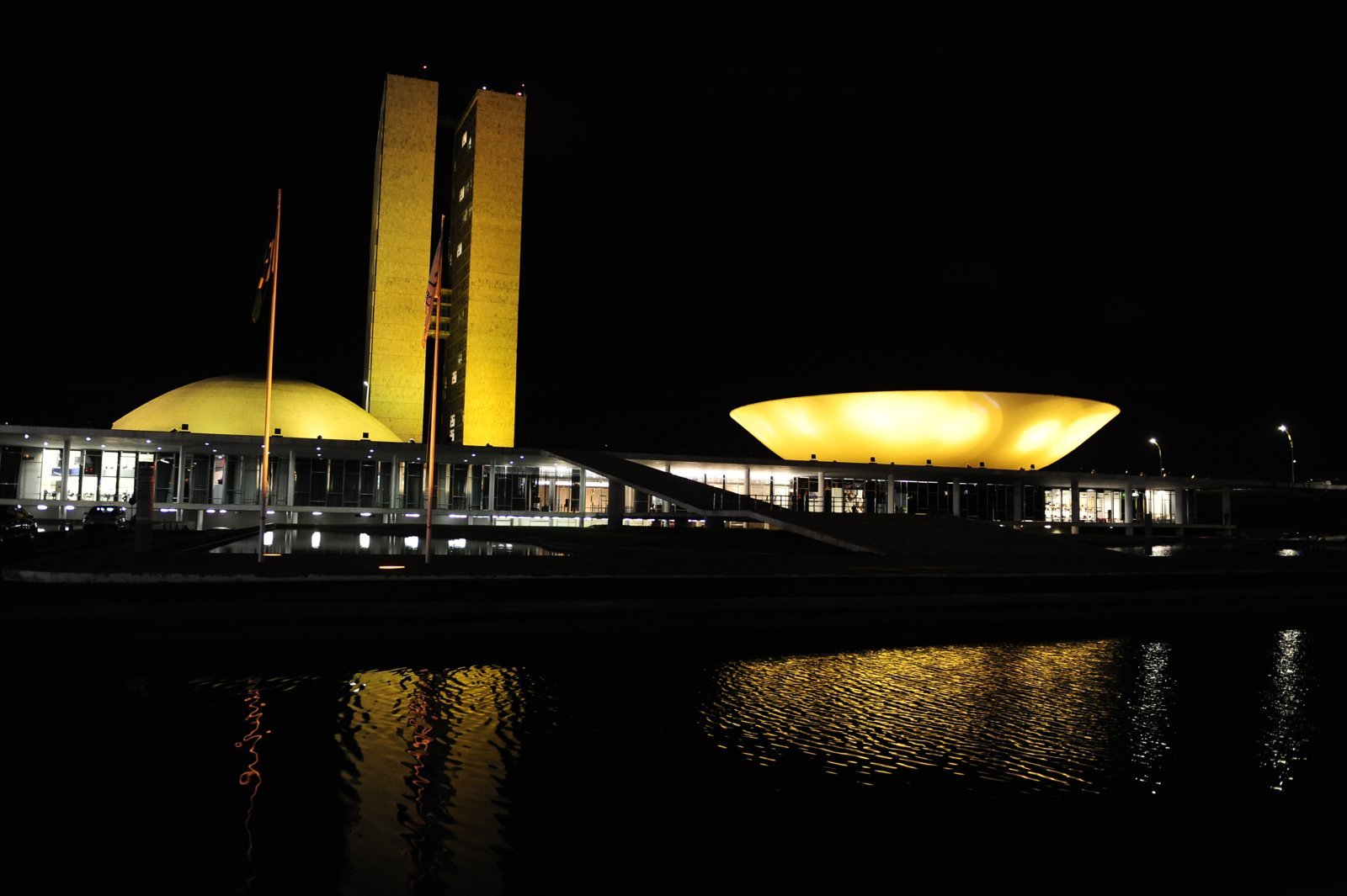 Congresso Nacional iluminado à noite, com as duas torres e as cúpulas do Senado e da Câmara, em Brasília