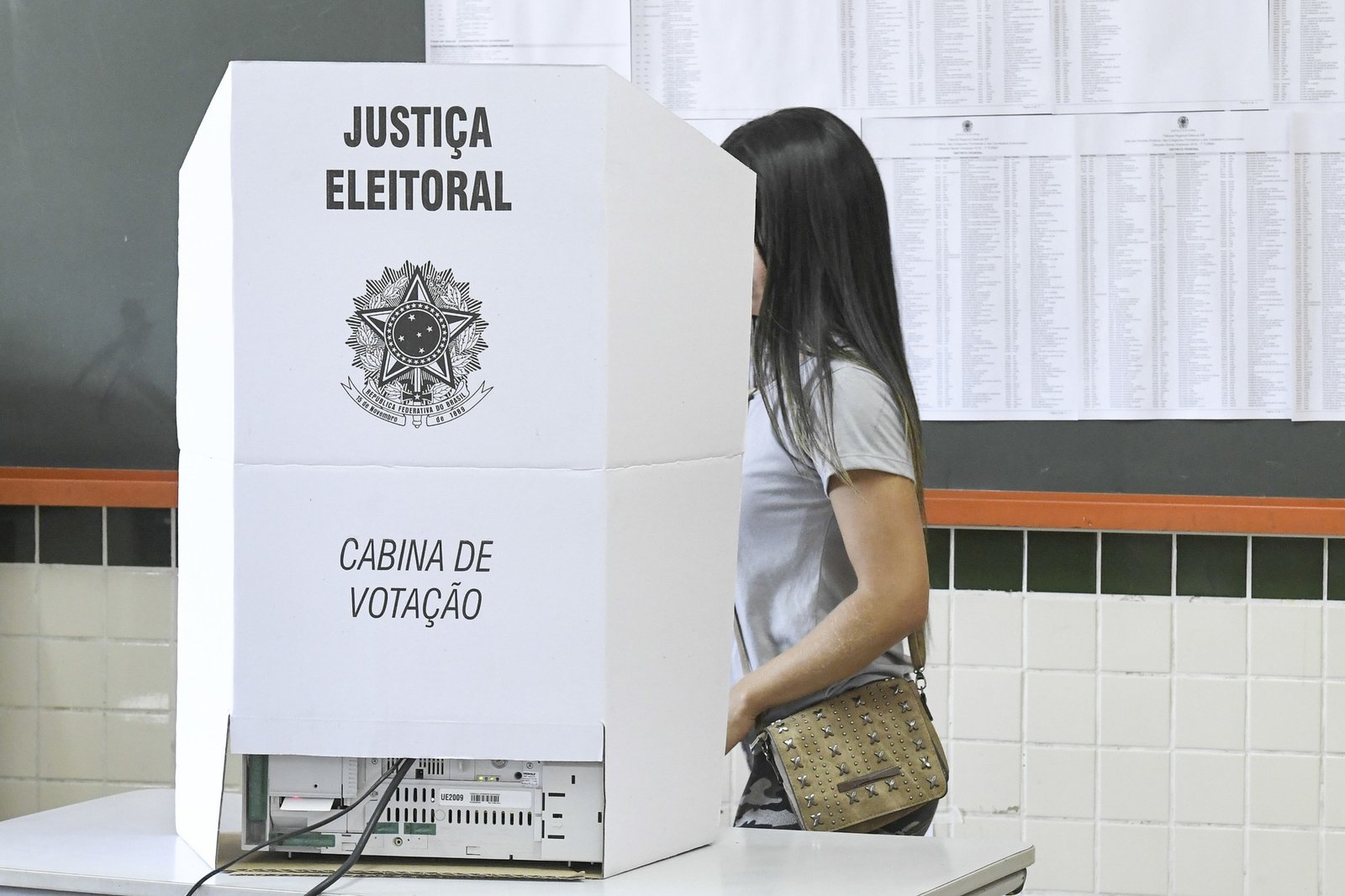 Cabina de votação da Justiça Eleitoral com urna eletrônica instalada em seção eleitoral no Brasil