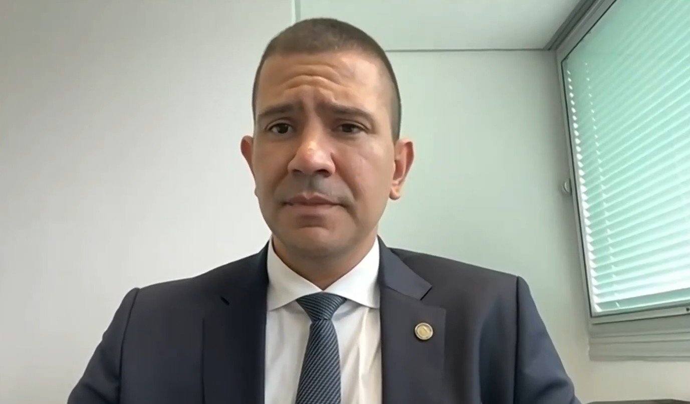 Douglas Ruas (PL), de terno escuro e gravata, em imagem de videoconferência