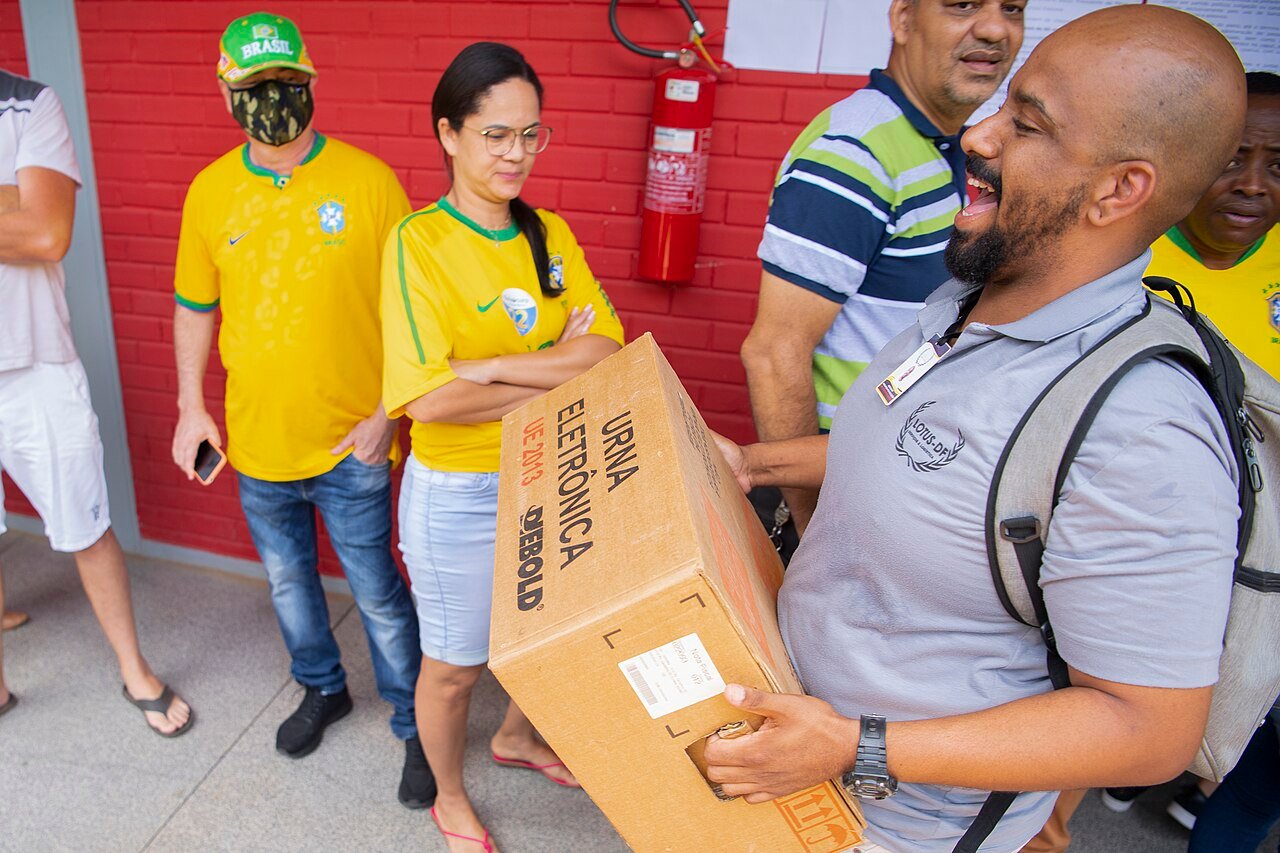 Servidor da Justiça Eleitoral carrega caixa de urna eletrônica em dia de votação