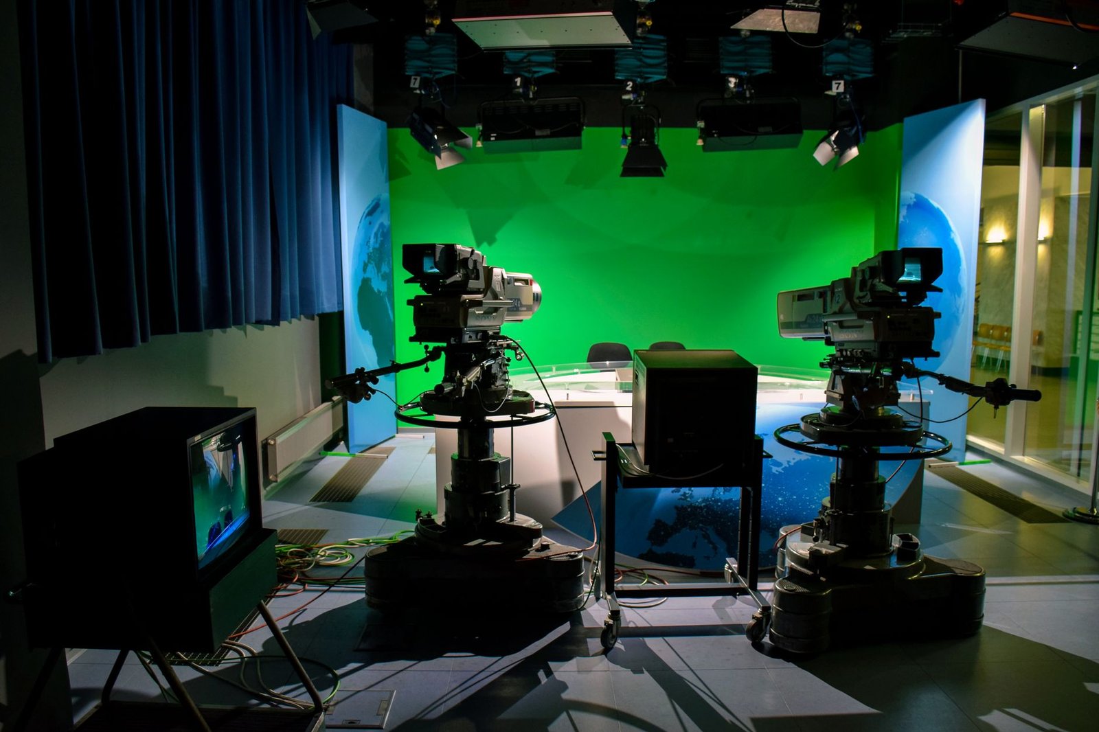 Estúdio de televisão com duas câmeras profissionais diante de cenário com fundo verde (foto ilustrativa, não é o estúdio da Band)