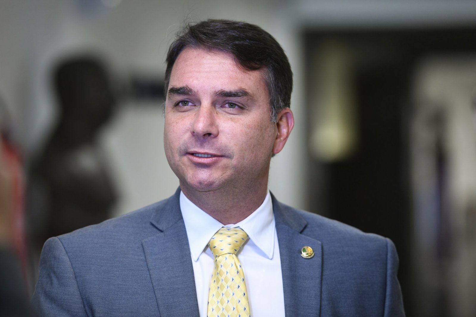 O senador Flávio Bolsonaro (PL-RJ) concede entrevista no Senado, de terno cinza e gravata amarela