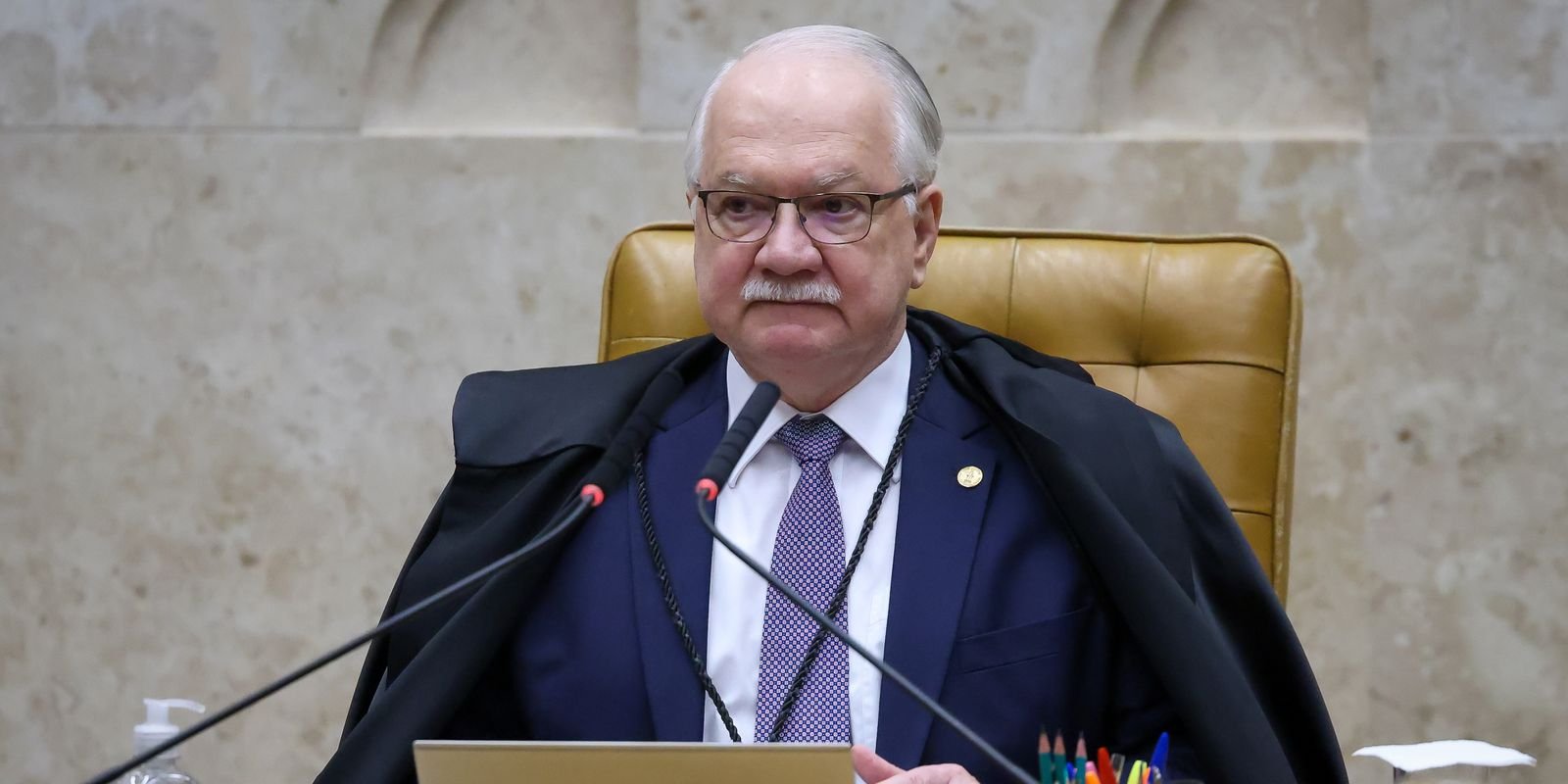 O ministro Edson Fachin, de toga, sentado na cadeira da presidência do Supremo Tribunal Federal durante sessão do plenário