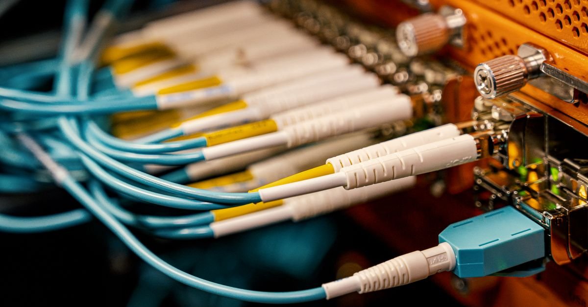Cabos de fibra óptica conectados a equipamento de rede de telecomunicações