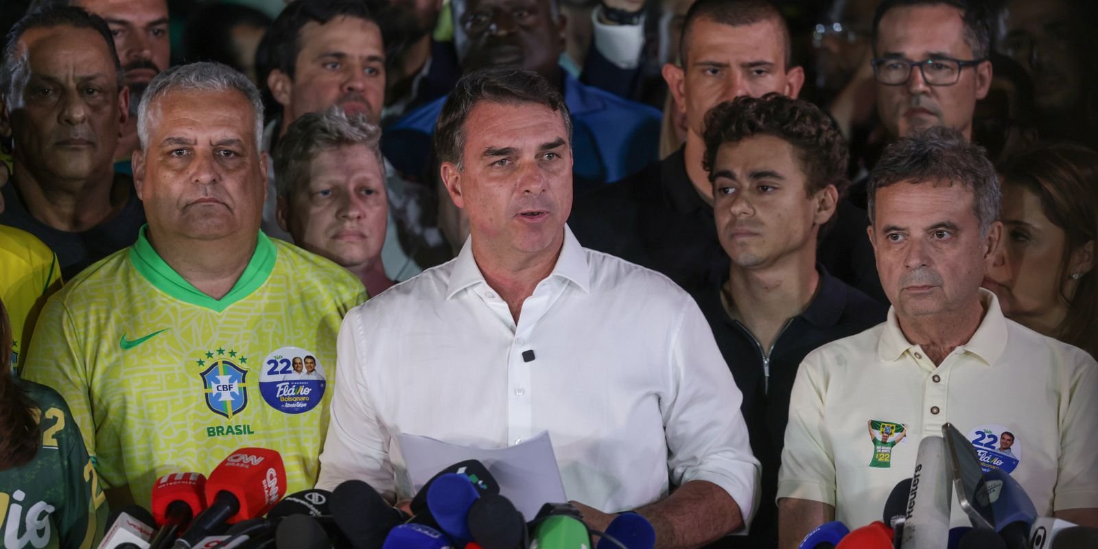 Flávio Bolsonaro fala à imprensa cercado de aliados na noite do segundo turno, em Brasília