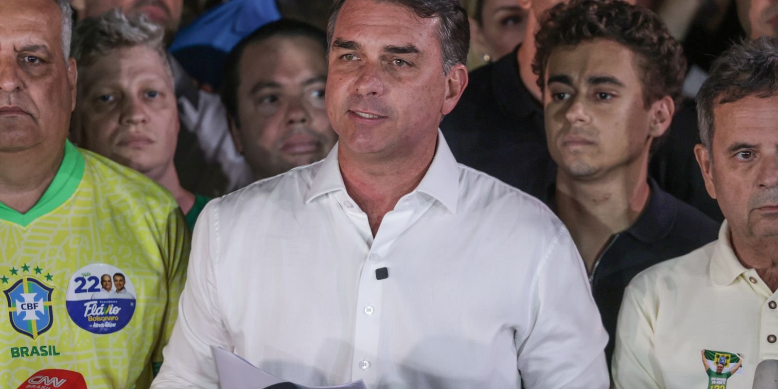O senador Flávio Bolsonaro lê um pronunciamento cercado de aliados após o segundo turno
