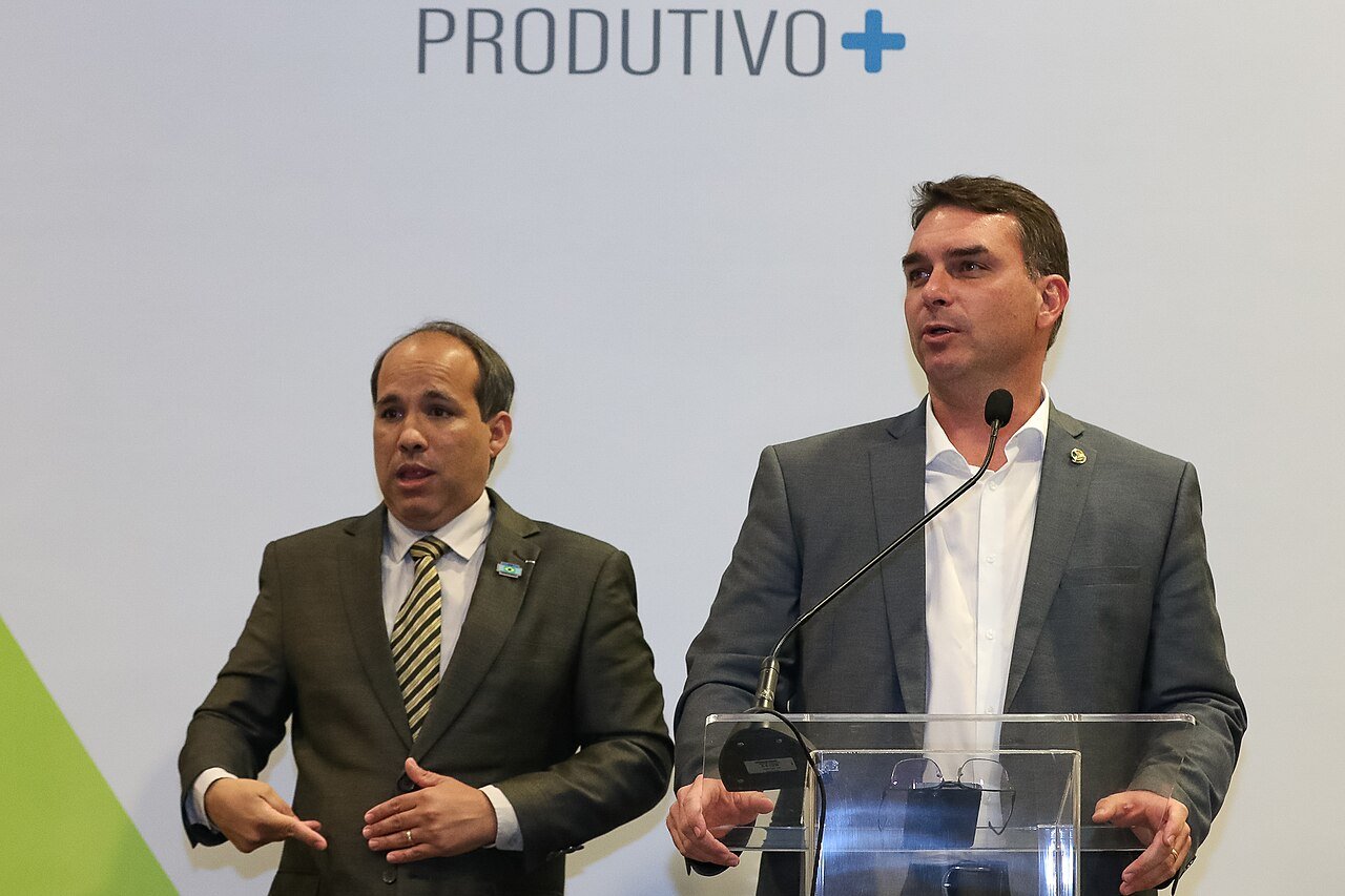 O senador Flávio Bolsonaro fala ao microfone em púlpito durante evento