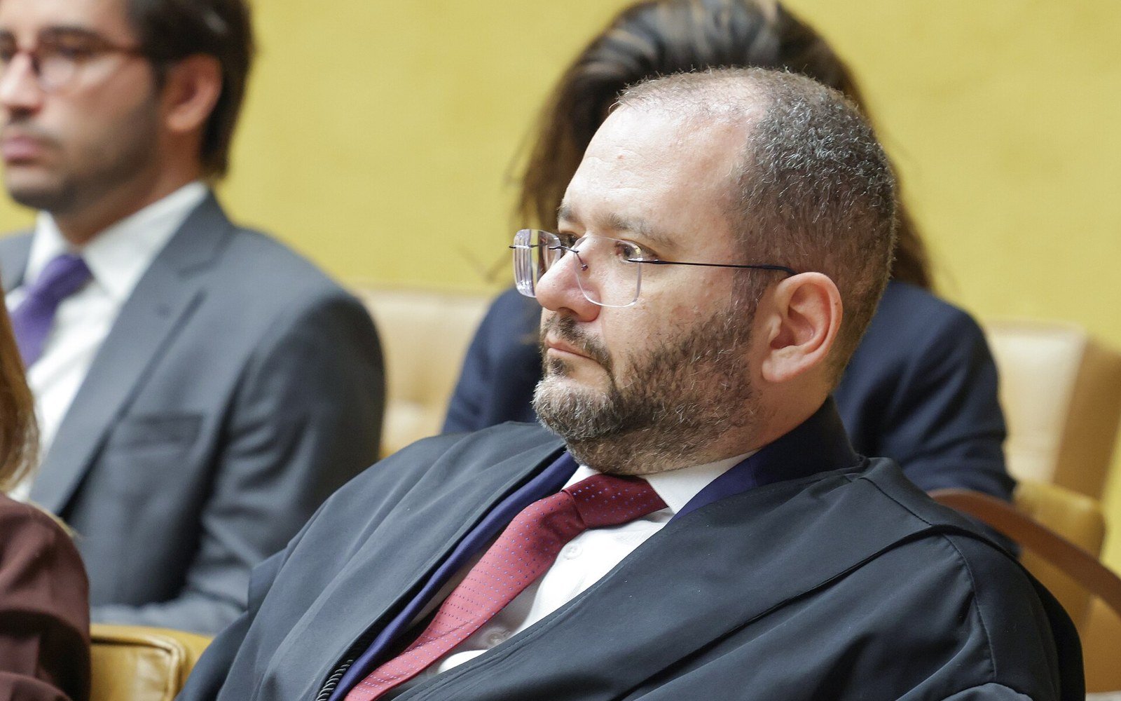 O ministro Flávio Dino, de toga, sentado em cadeira do plenário do Supremo Tribunal Federal