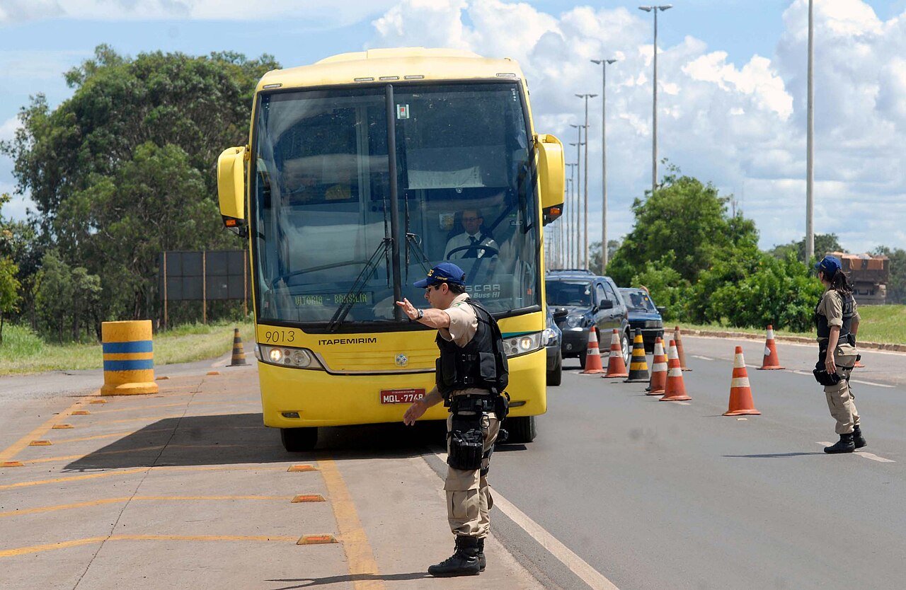 Agentes da Polícia Rodoviária Federal fazem abordagem a ônibus durante fiscalização em rodovia
