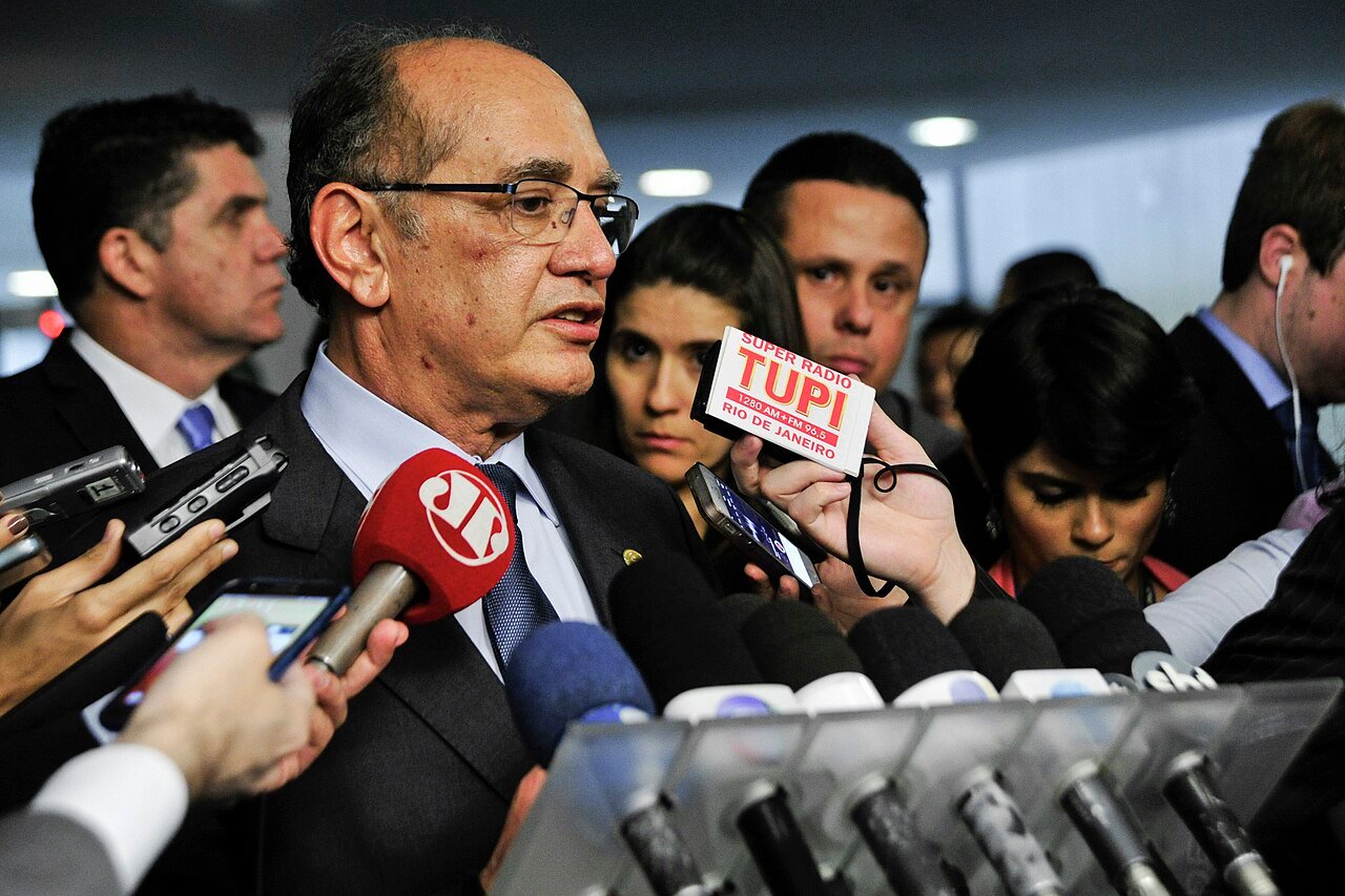 Ministro Gilmar Mendes fala a jornalistas cercado de microfones