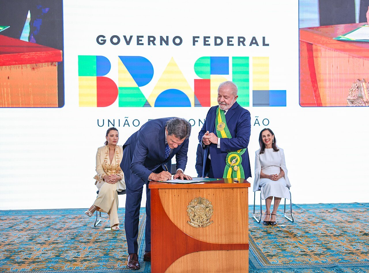 Fernando Haddad assina o termo de posse como ministro da Fazenda ao lado do presidente Lula, em 1º de janeiro de 2023, no Palácio do Planalto