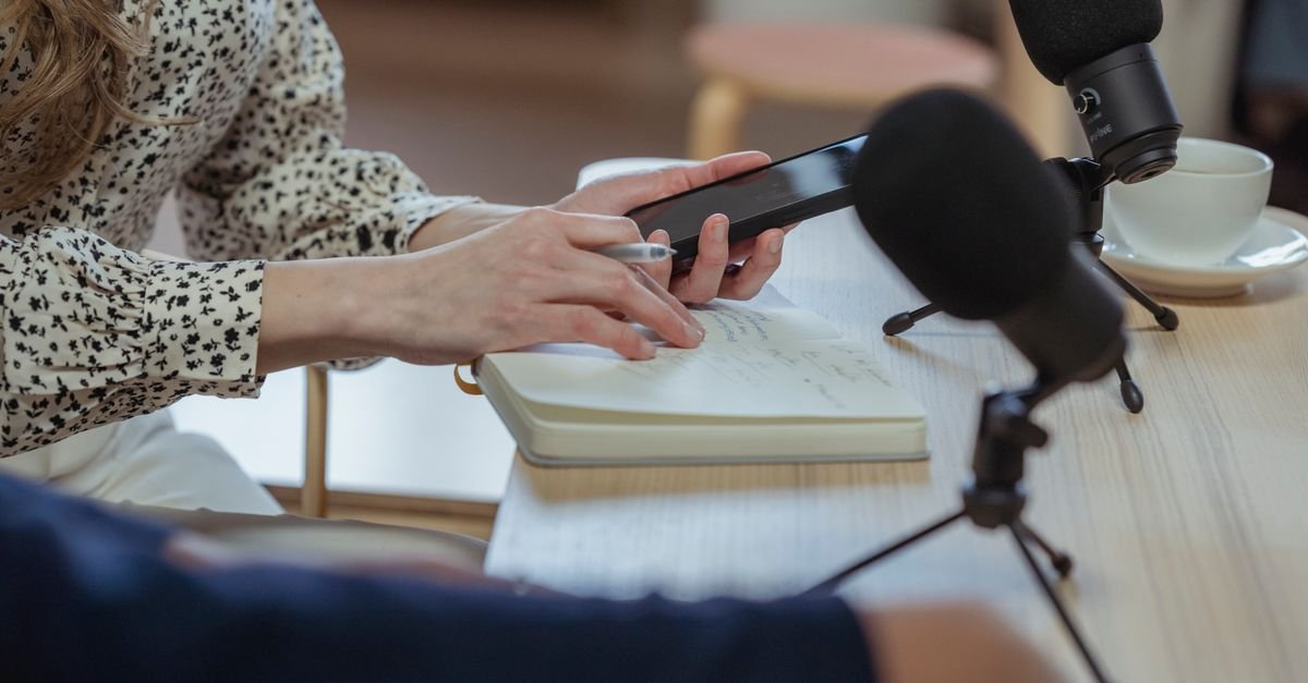 Microfones e caderno de anotações sobre uma mesa durante uma entrevista