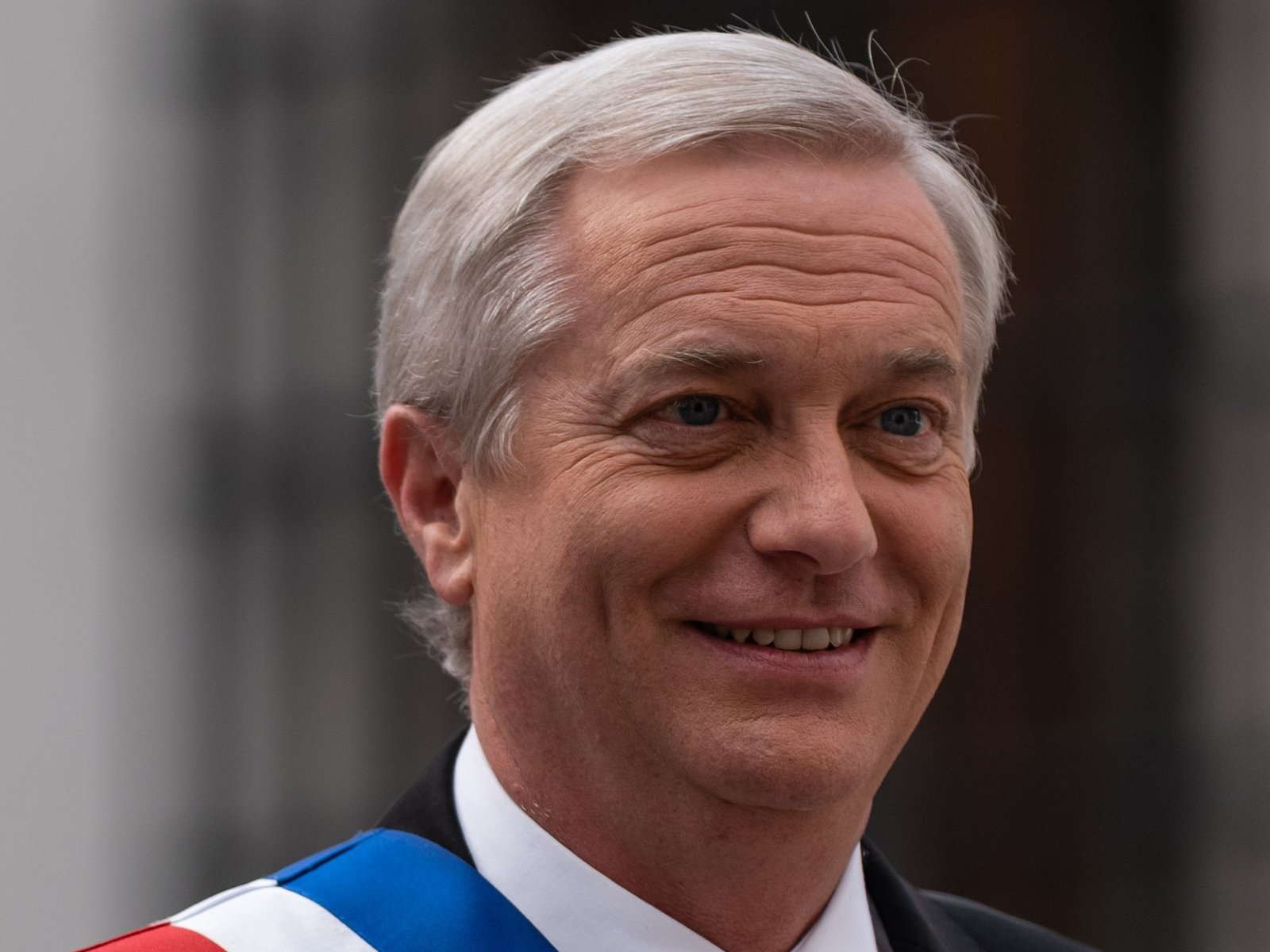 O presidente do Chile, José Antonio Kast, de faixa presidencial, sorrindo em frente ao palácio de La Moneda