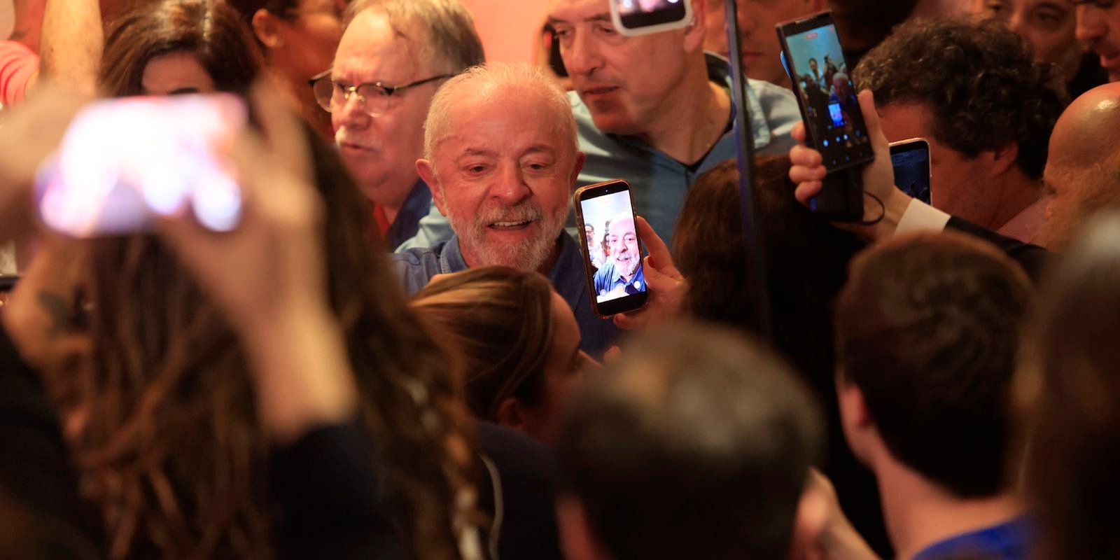 O presidente Lula, cercado de apoiadores com celulares em punho, após discursar no hotel InterContinental, em São Paulo