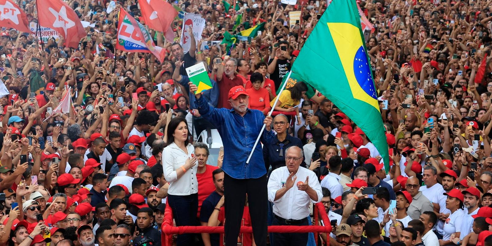 Lula acena com exemplar da Constituição e bandeira do Brasil entre apoiadores na Avenida Paulista, em São Paulo, em 24 de outubro de 2026