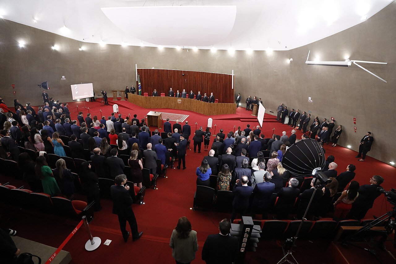 Vista do alto do plenário do Tribunal Superior Eleitoral durante sessão solene, com público em pé