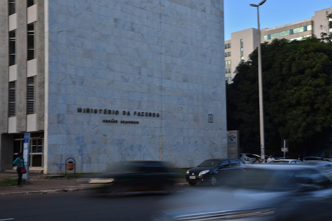 Fachada de edifício do Ministério da Fazenda em Brasília com carros passando na via