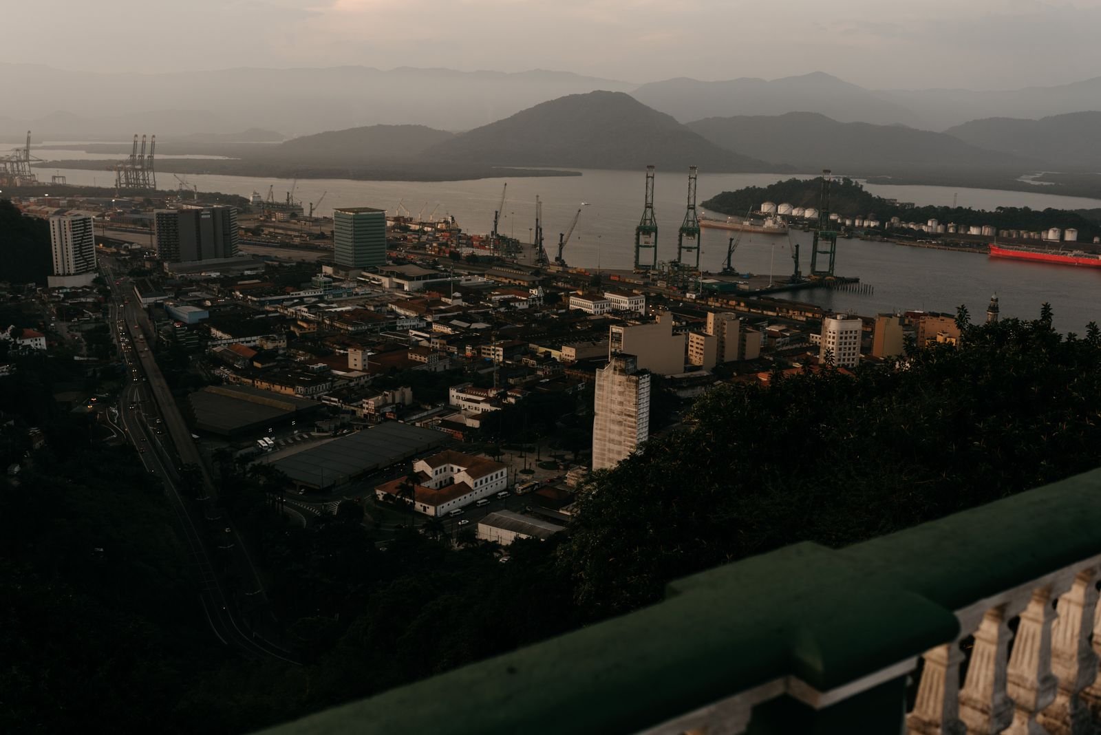 Vista aérea do porto de Santos, com guindastes de cais e navios, ao entardecer