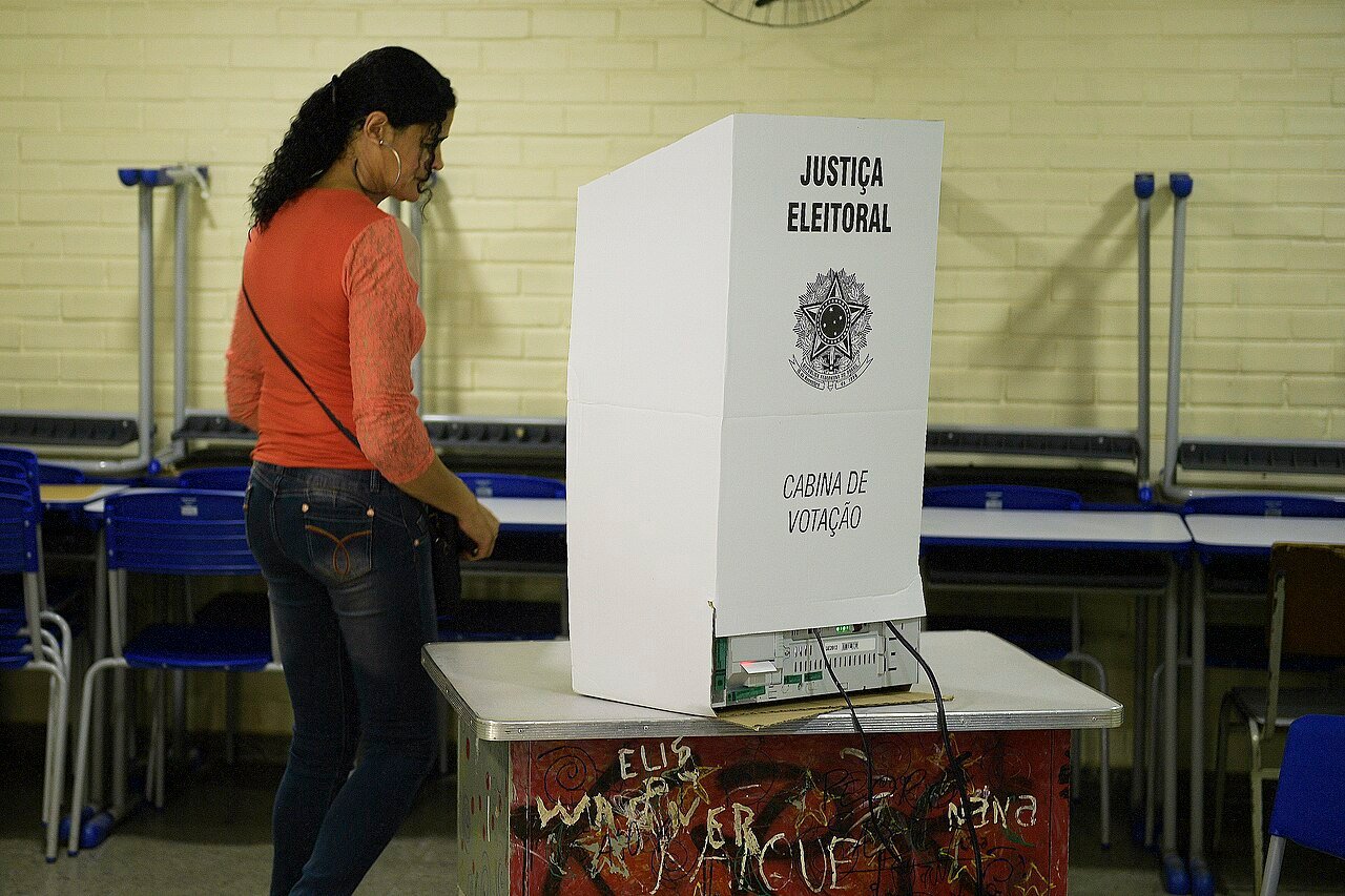 Eleitora diante de uma cabine de votação da Justiça Eleitoral, em foto de arquivo do primeiro turno de 2018