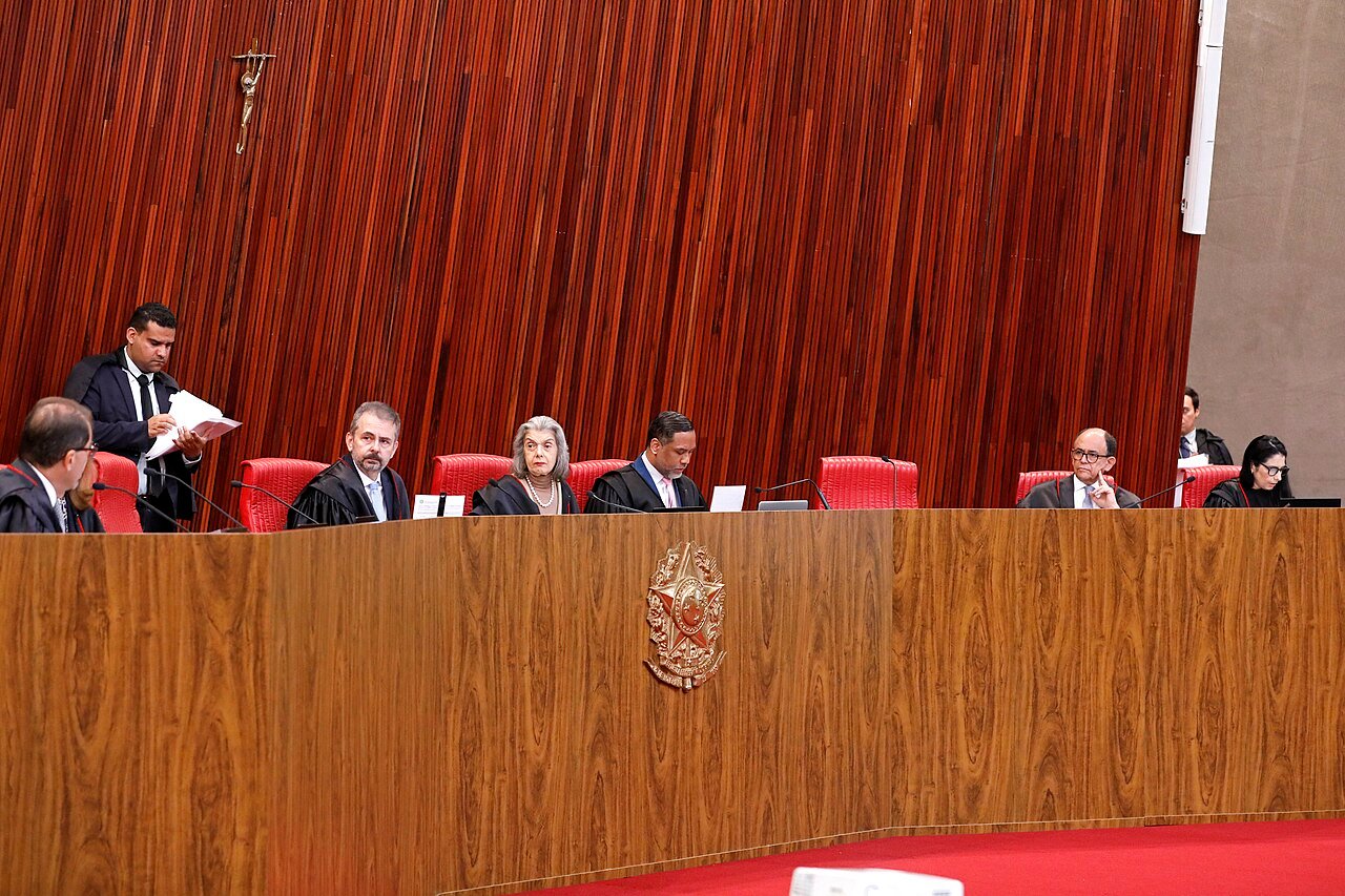 Plenário do Tribunal Superior Eleitoral, com ministros sentados à bancada de madeira sob o brasão da República, em sessão de arquivo
