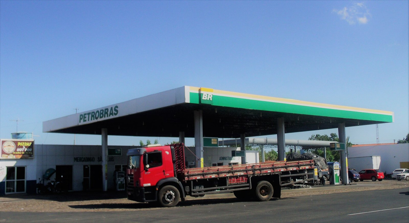 Posto de combustível da bandeira Petrobras com caminhão de carga estacionado ao lado das bombas