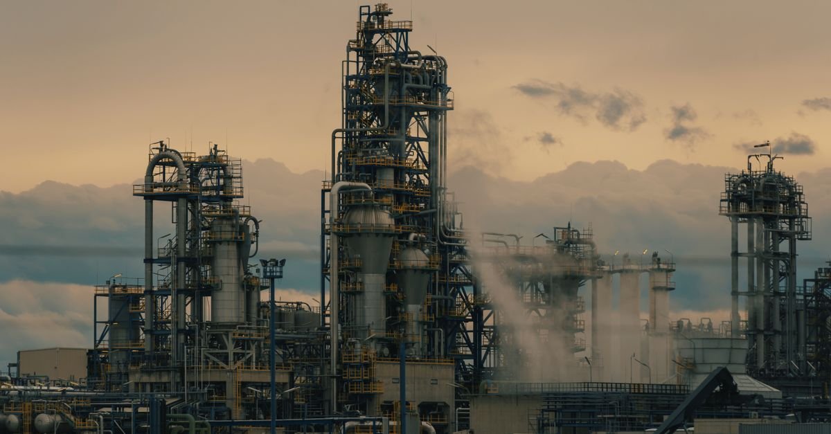 Torres de destilação de uma refinaria de petróleo ao entardecer