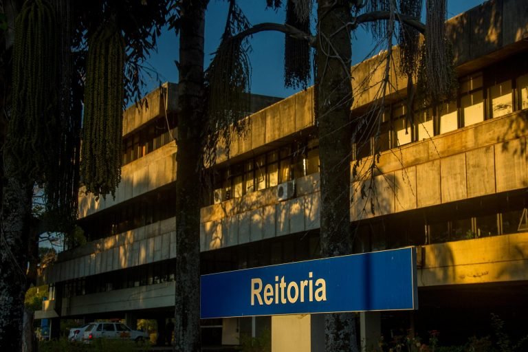 Placa da Reitoria da Universidade de Brasília em frente ao prédio, ao entardecer
