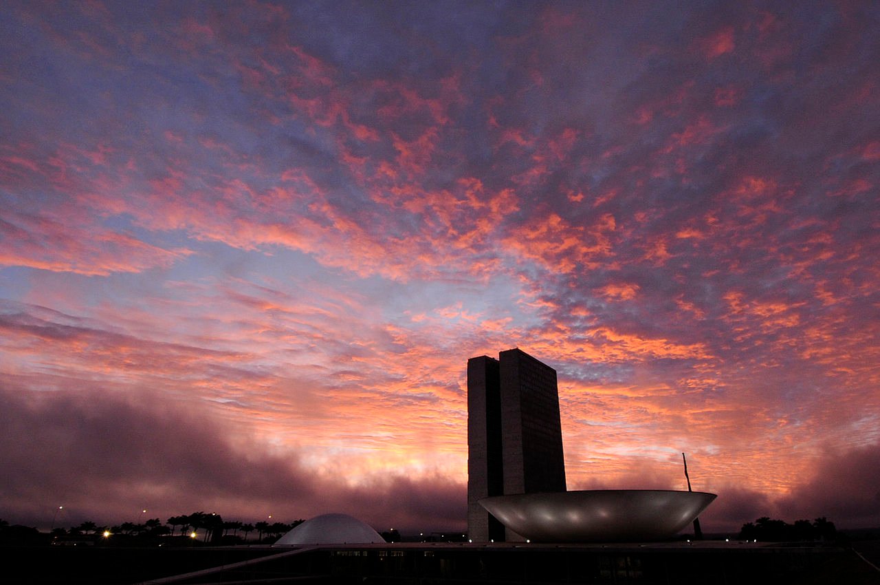 Silhueta do Congresso Nacional, em Brasília, contra o céu alaranjado do fim de tarde