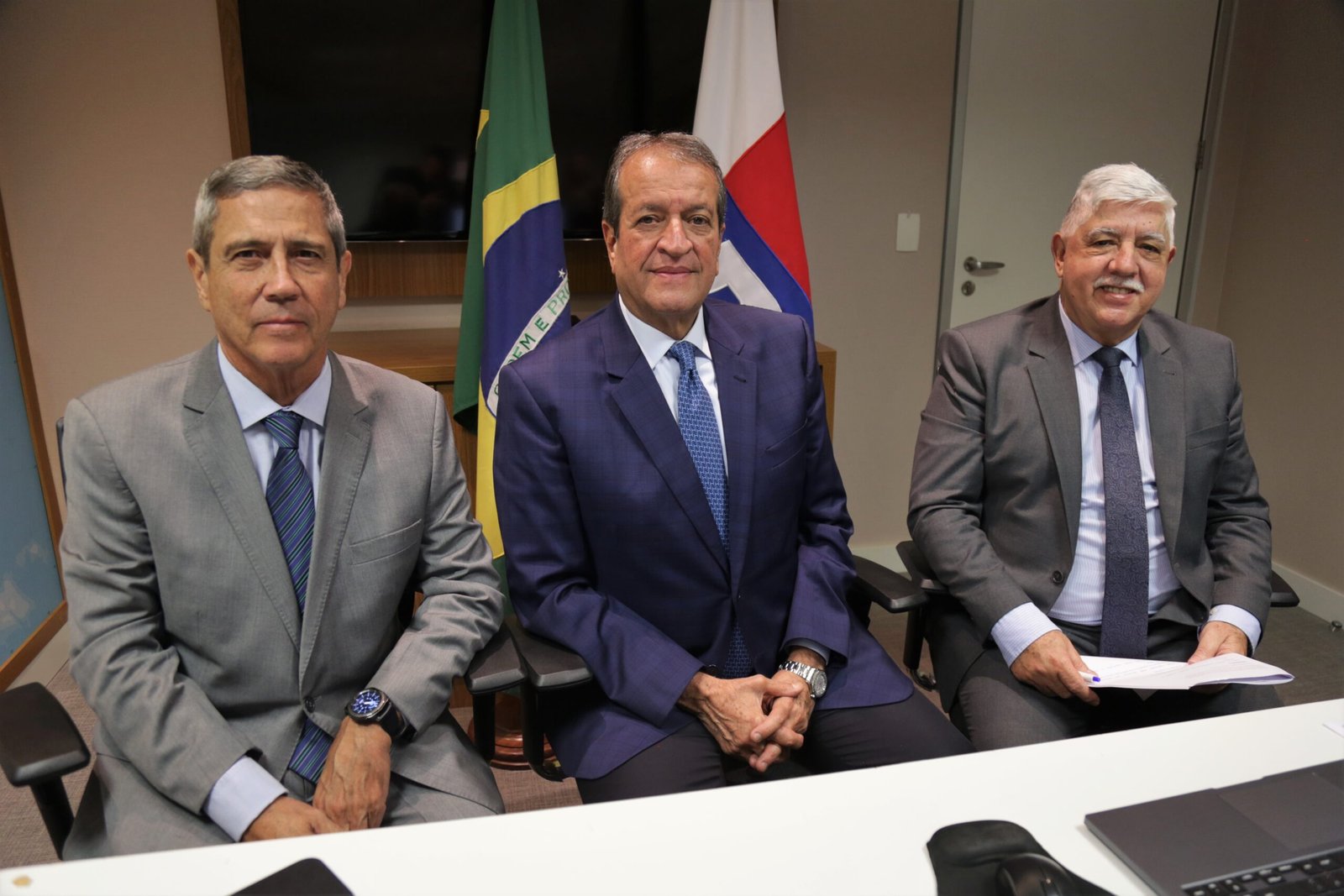 Três homens de terno sentados diante de uma bandeira do Brasil e de outra do partido, em evento do PL em 2022 (foto de arquivo)