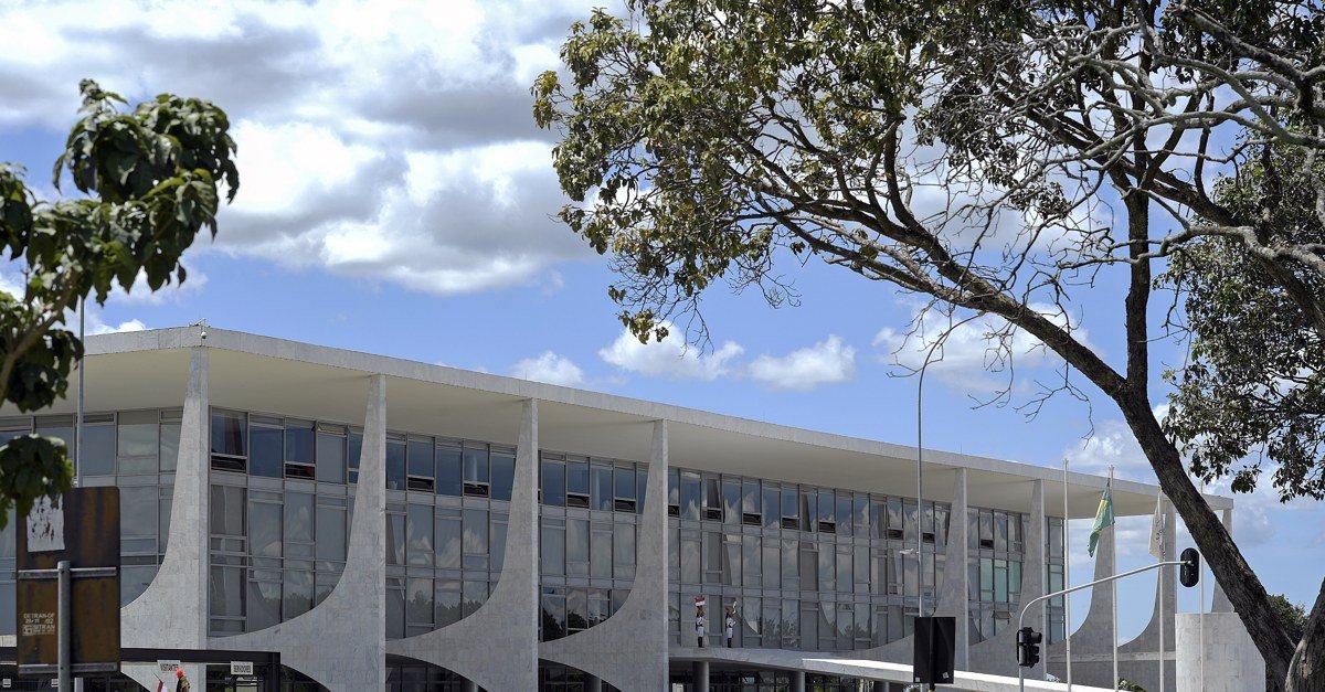 Fachada do Palácio do Planalto com a bandeira do Brasil hasteada ao lado do prédio