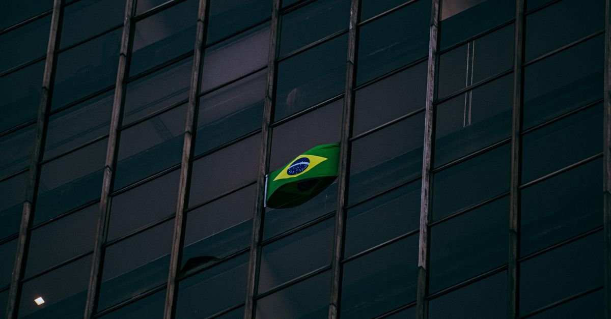 Bandeira do Brasil hasteada em fachada de predio