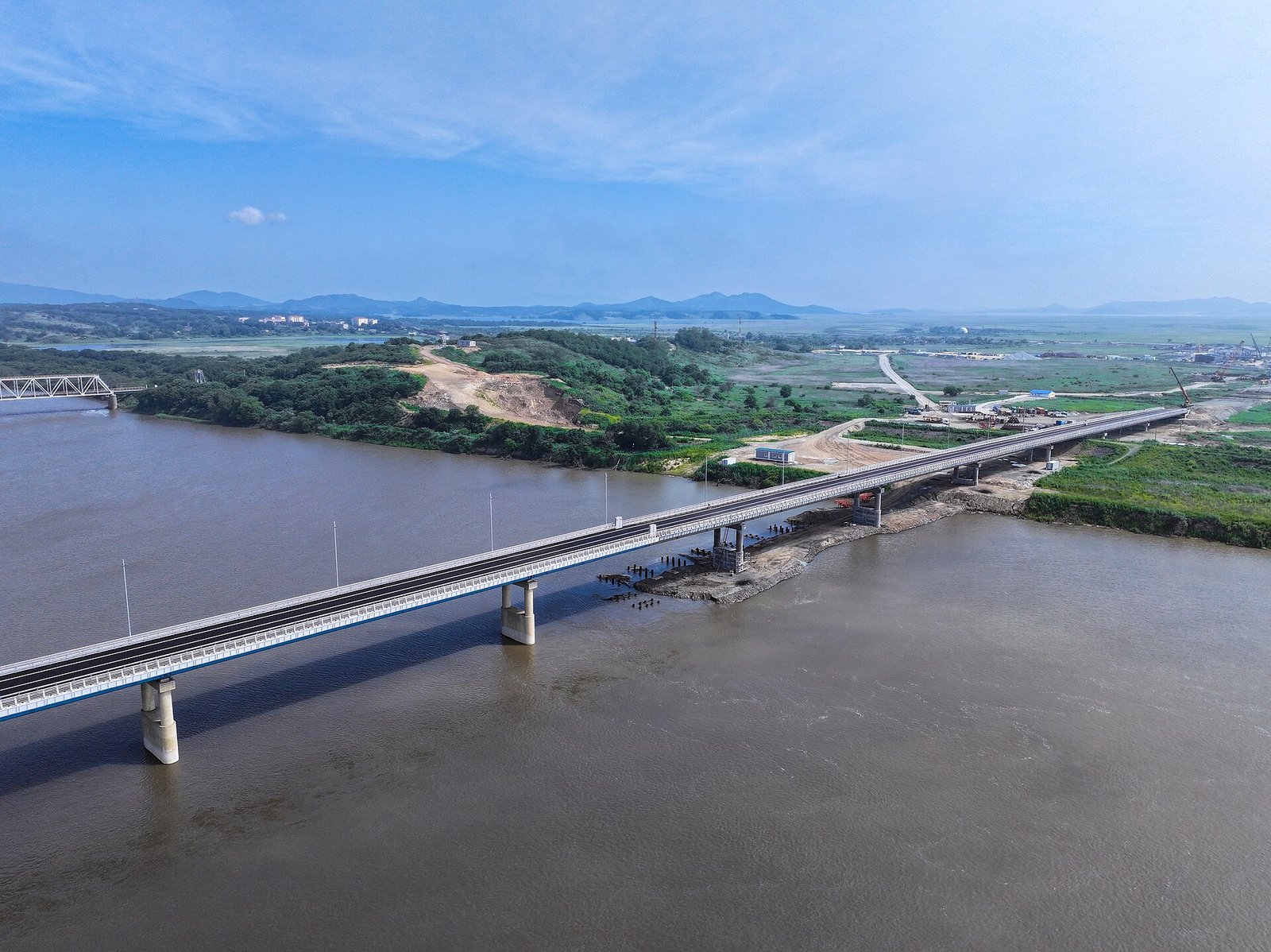 Vista aérea da ponte rodoviária Yakov Novichenko sobre o rio Tumen, entre Khasan, na Rússia, e Tumangang, na Coreia do Norte; à esquerda, a antiga ponte ferroviária da Amizade
